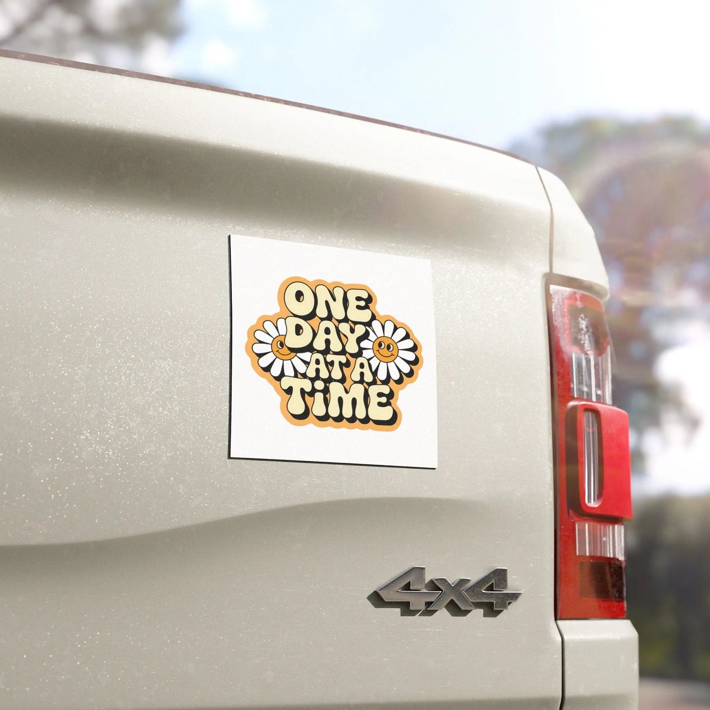 SoberSips Recovery retro daisy 'One Day At A Time' magnetic decal applied to the back of a silver truck.