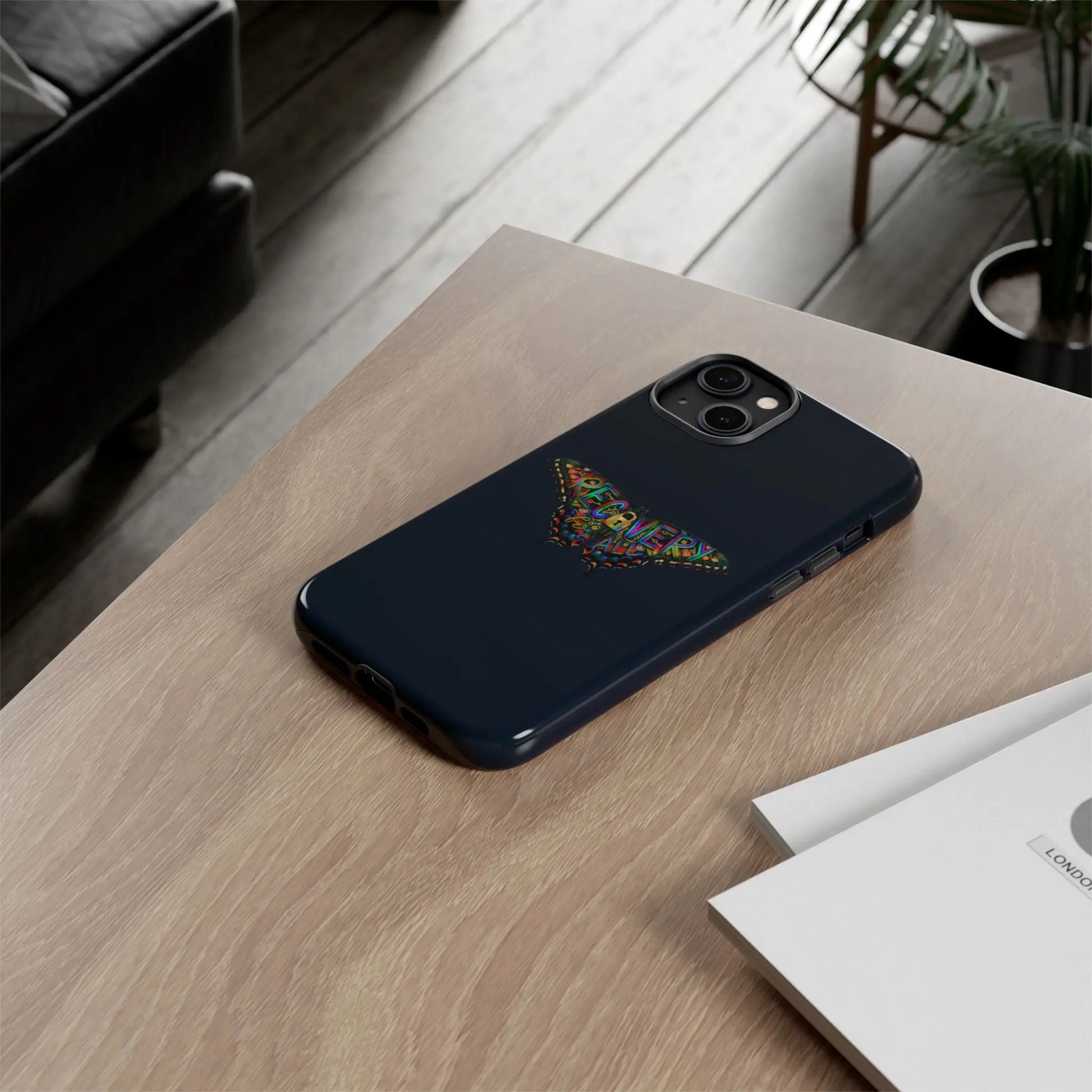 Black phone case with a spider design on a wooden surface